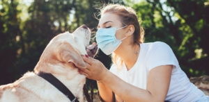 girl in medical mask with her dog